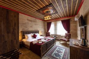 a bedroom with a bed and a table and chairs at Volare Stone Hotel in Nevşehir