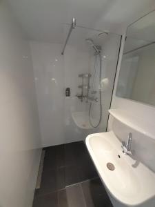 a white bathroom with a sink and a shower at Historic Centre Hotel in Amsterdam