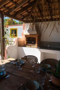 einen Holztisch mit Stühlen und einen Kamin auf der Terrasse in der Unterkunft Casa Ferrobo in São Brás de Alportel