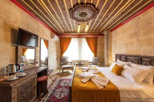 um quarto de hotel com uma cama, uma mesa e cadeiras em Volare Stone Hotel em Nevşehir