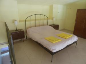 um quarto com uma cama com duas toalhas amarelas em CASA IN MAREMMA TOSCANA em Monticello