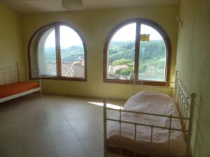 una camera da letto con due finestre e un letto in esso di CASA IN MAREMMA TOSCANA a Monticello