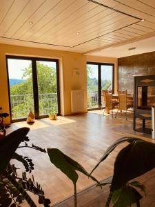 uma sala de estar com pisos de madeira e janelas grandes em Heidrun's Home em Altendiez