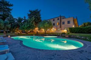 a swimming pool in the middle of a yard at night at Alghero Resort Country Hotel & Spa in Alghero