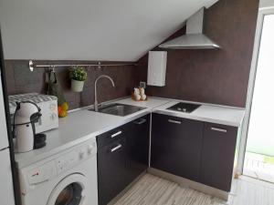a kitchen with a sink and a washing machine at Bemar Loft in Costa da Caparica