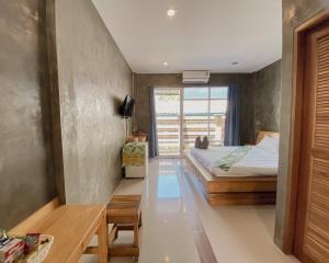 春蓬的住宿－瓦里奇度假村，一间卧室配有一张床、一张桌子和一个窗户。