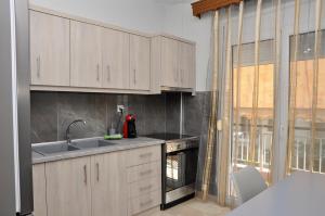 a kitchen with white cabinets and a sink and an oven at Friendly Flat 3 in Edessa
