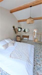 sypialnia z dużym białym łóżkiem i umywalką w obiekcie Cosy love house w mieście Saint-Siffret