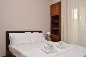 Un dormitorio con una cama blanca con toallas. en Friendly Flat 3 en Edessa