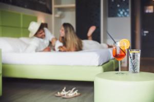 a table with a drink and a couple in a bed at Hotel La Fiorita in Limone sul Garda