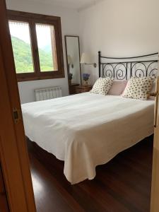 um quarto com uma cama grande com lençóis brancos e uma janela em El Mirador de Llanars em Llanars