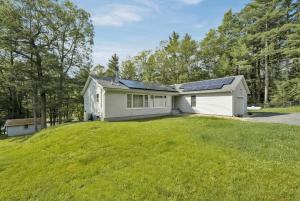 a house with solar panels on top of a yard at Spacious Catskills Serenity nearby Delaware River Gap w Game Rm Pet Friendly and Fenced Yard in Glen Spey