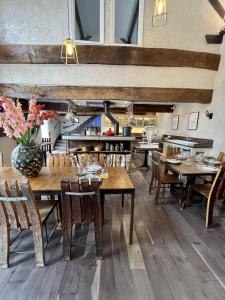 une salle à manger avec des tables et des chaises en bois dans l'établissement Les Perséides, à Lézignan