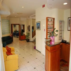 ein Wohnzimmer mit einem gelben Sofa und einer Lobby in der Unterkunft Hotel Danubio in San Mauro a Mare
