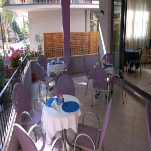 Habitación con mesas, sillas y balcón. en Hotel Danubio, en San Mauro a Mare