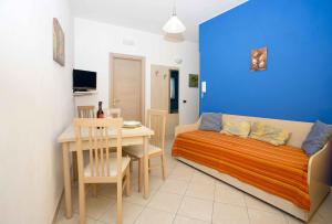 um quarto com uma cama e uma mesa com uma sala de jantar em Terra del Sole em Favignana