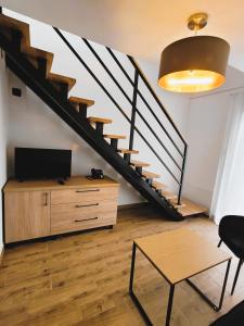 a living room with a staircase and a television at Dwór Kombornia - Folwark in Kombornia