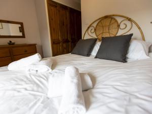 a bedroom with a white bed with towels on it at Pass the Keys Cosy cottage with views over the Shropshire hills in Ludlow