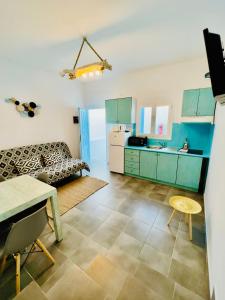 a kitchen with green cabinets and a dining room at Family Villages Santorini in Vlychada Beach