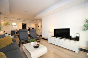 a living room with a couch and a flat screen tv at Estepona East Apartment DAISY in Estepona