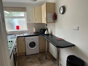 a small kitchen with a washing machine and a sink at Castle View Dover in Dover