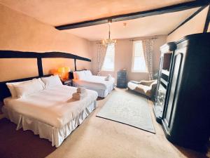 a bedroom with two beds and a flat screen tv at George & Dragon Hotel in Buckinghamshire