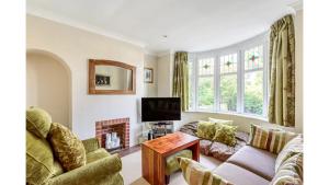 ein Wohnzimmer mit einem Sofa und einem TV in der Unterkunft Pass the Keys Lovely 3 Bedroom Garden Home in Oxford in Oxford