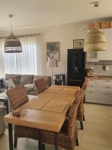 a kitchen and living room with a wooden table and chairs at ApartGolf Sobienie Królewskie in Sobienie Szlacheckie