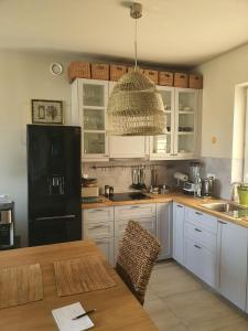 a kitchen with white cabinets and a black refrigerator at ApartGolf Sobienie Królewskie in Sobienie Szlacheckie