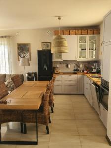 a kitchen with a wooden table and a dining room at ApartGolf Sobienie Królewskie in Sobienie Szlacheckie