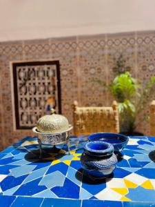 una mesa con dos platos azules y blancos. en Riad White House en Marrakech