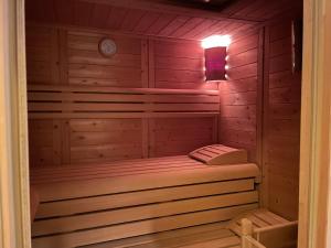 uma sauna com um banco num camarote de madeira em Schöne Wohnung mit Pool und Sauna zum Wohlfühlen em Oberhausen