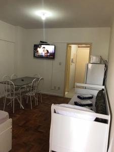 um quarto com uma mesa e uma televisão na parede em Estúdio 73 em São Paulo