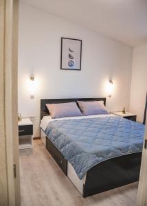 a bedroom with a large bed with blue sheets at Apartments Olea in Biograd na Moru