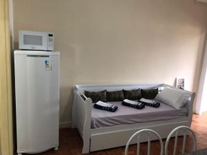 a bed with pillows and a microwave on top of it at Estúdio 73 in São Paulo