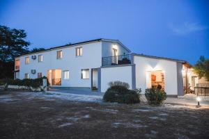 a large white house at night with a yard at Apartments Olea in Biograd na Moru