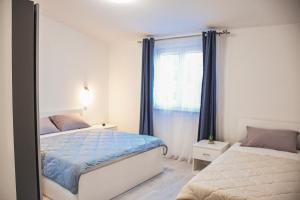 1 dormitorio con 2 camas y ventana en Apartments Olea en Biograd na Moru