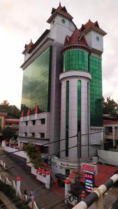 a large building with a green and white at hotel bessota international in Thiruvalla