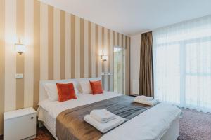 1 dormitorio con 1 cama grande y 2 toallas. en Aqua Metropol, en Băile Felix