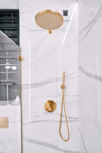 a bathroom with a shower with white marble walls at Apartament Zamojski Rynek in Zamość