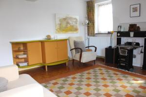 a living room with a yellow cabinet and a chair at Vakwerkvakantiehuis Eckelmus in Eckelrade
