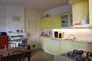 a kitchen with yellow cabinets and a table and a tableablish at Vakwerkvakantiehuis Eckelmus in Eckelrade