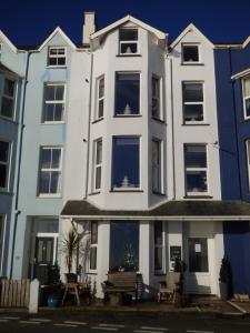 a white building with blue windows on a street at Cadair Idris in Criccieth