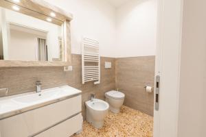Un baño con lavabo, inodoro y espejo. en Ancient Rome Room, en Roma