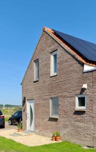 a brick house with a car parked in front of it at Maisonnette Slijkplaat 18 in Hoofdplaat