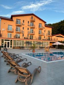 a large building with chairs next to a swimming pool at Aqua Metropol in Baile Felix