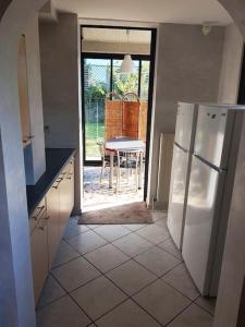 a kitchen with a white refrigerator and a table at L'Escale du Monde in Vénissieux