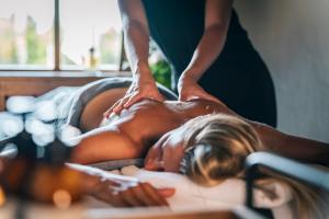 a woman getting a massage from a therapist at Hôtel Les Peupliers in Courchevel