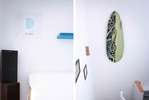 a surfboard hanging on a wall next to a refrigerator at Surf House Gran Canaria in Las Palmas de Gran Canaria