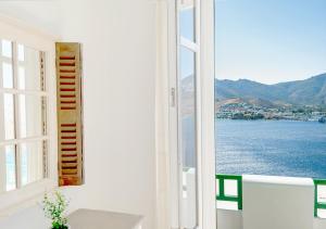 a room with a window with a view of the water at Astrio Suites in Livadi